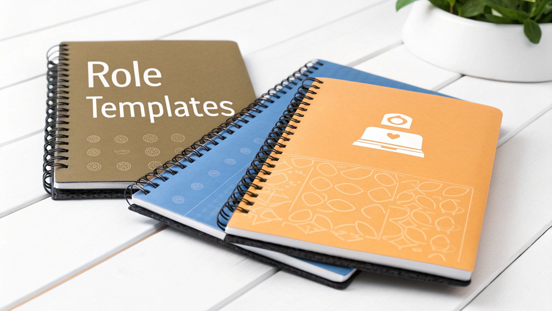 Three spiral-bound journals, including one labeled 'Role Templates', on a white wooden table.